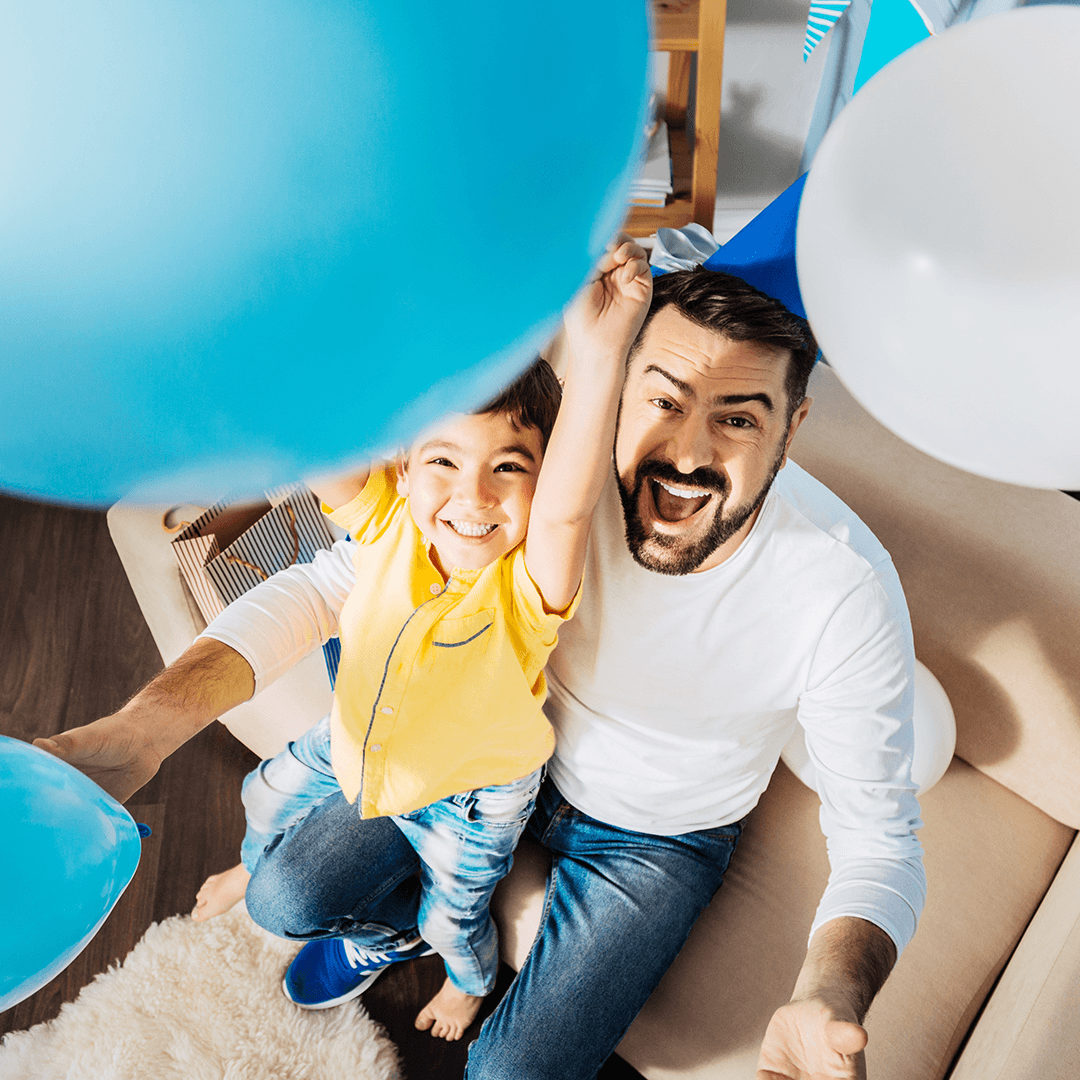 Father and son playing with balloons in the living room – simple indoor birthday party games for children made easy at home.