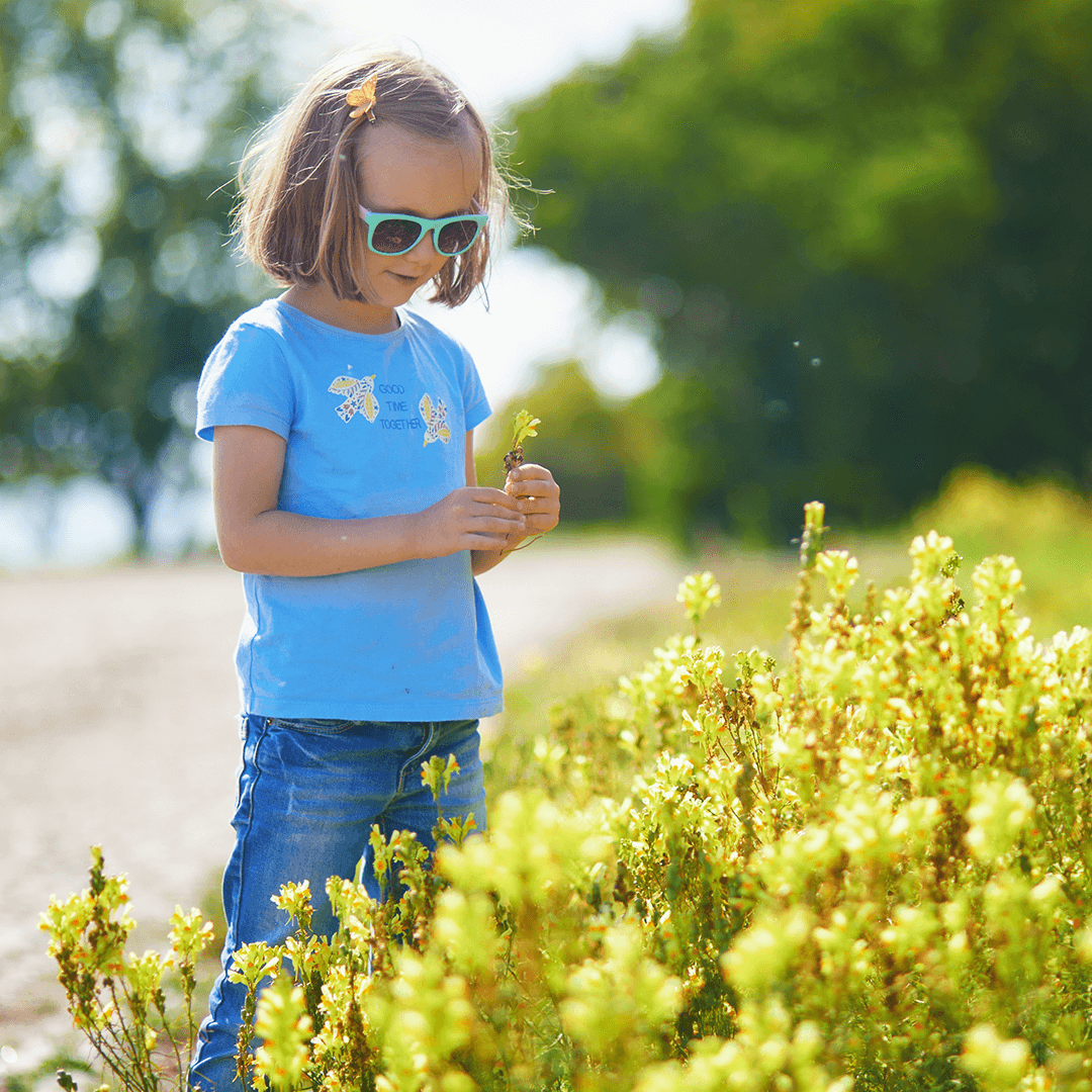 Tyttö nauttii kesäpäivästä kukkien keskellä – ihanaa tekemistä lapsille Helsingissä luonnon helmassa