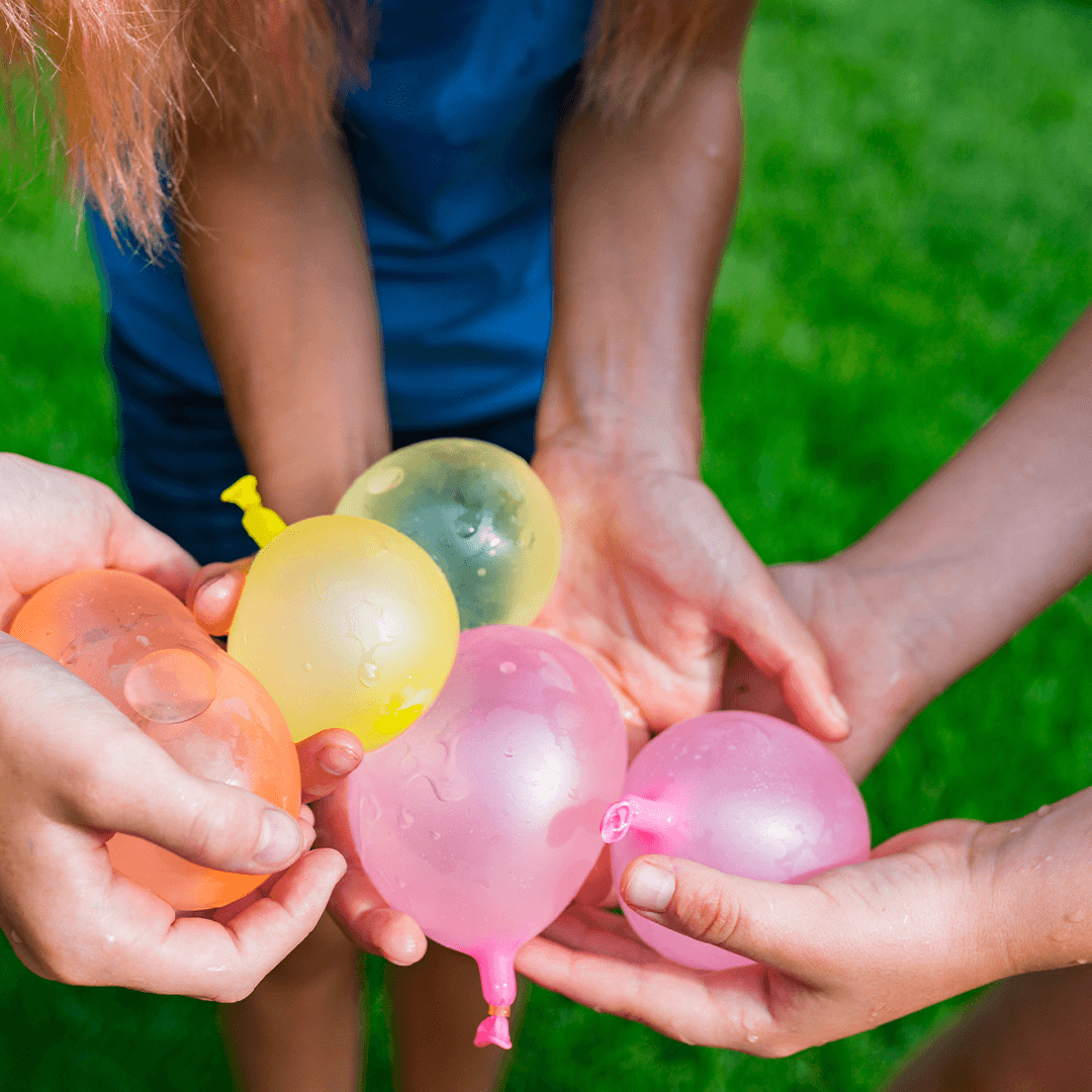 Lapset leikkivät vesi-ilmapalloilla – liikunnallista kesätekemistä lapsille