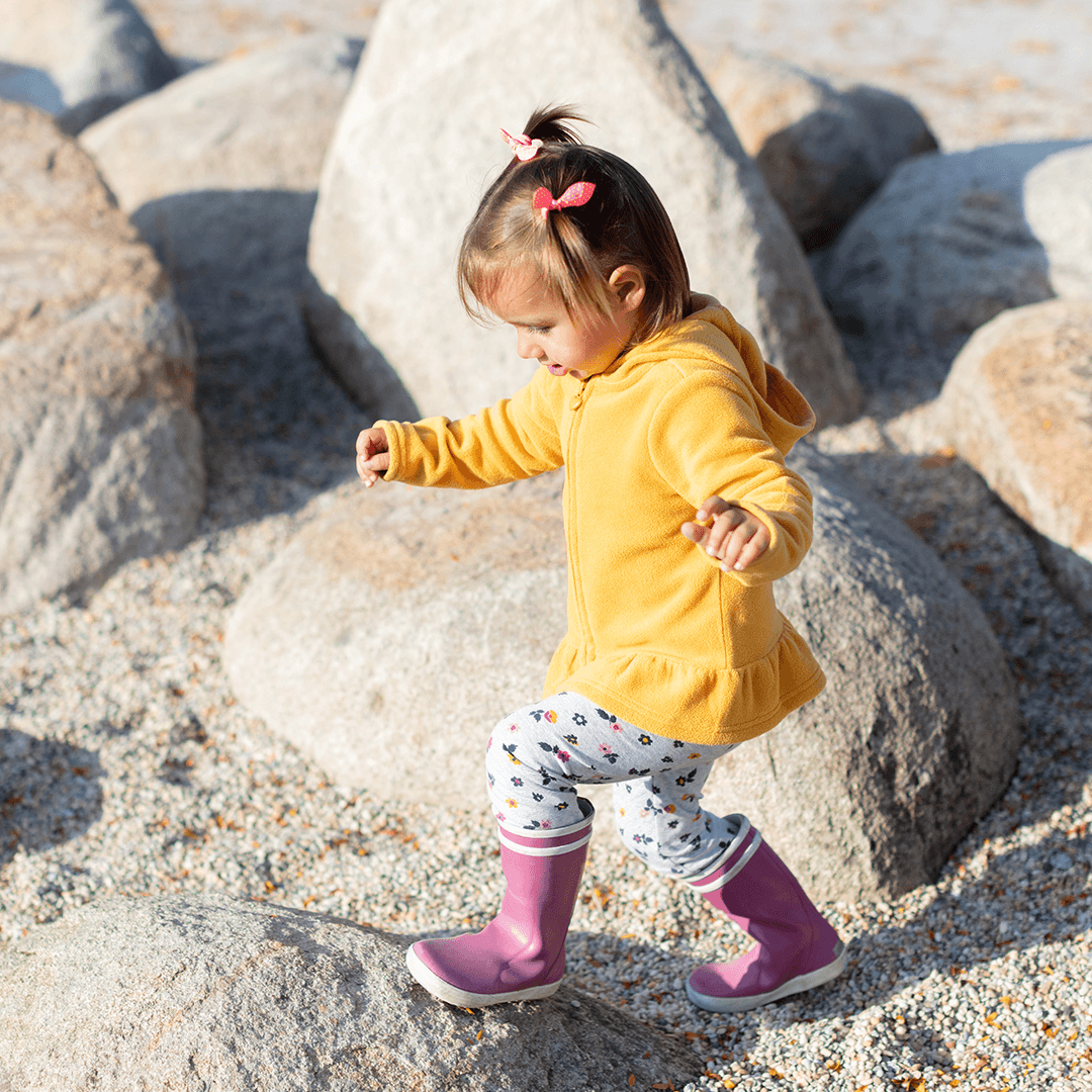 Tyttö tasapainoilee kivillä – lasten liikkuminen tukee kehon hallintaa