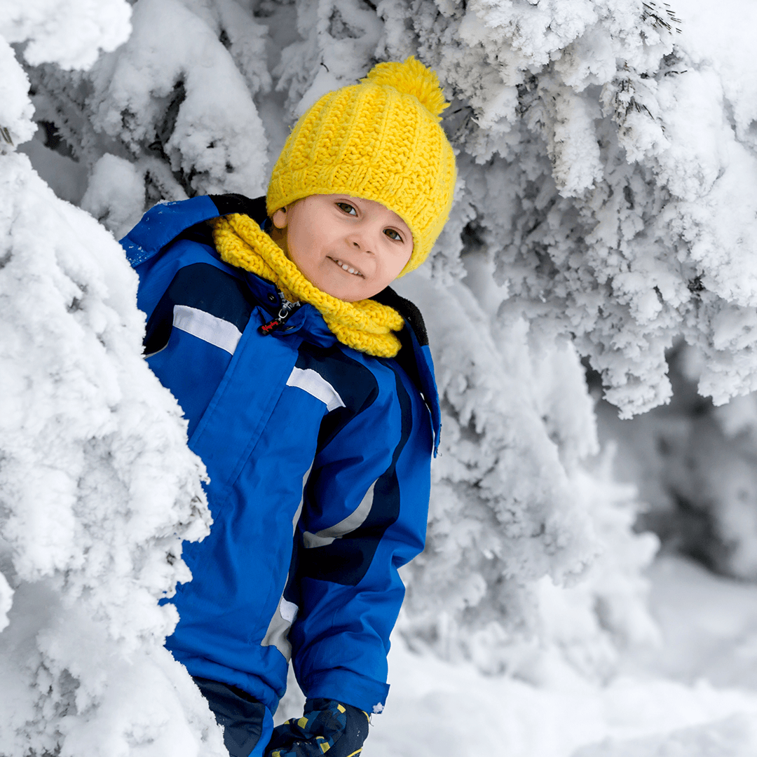 Boy playing outside in snowy weather on a winter break day